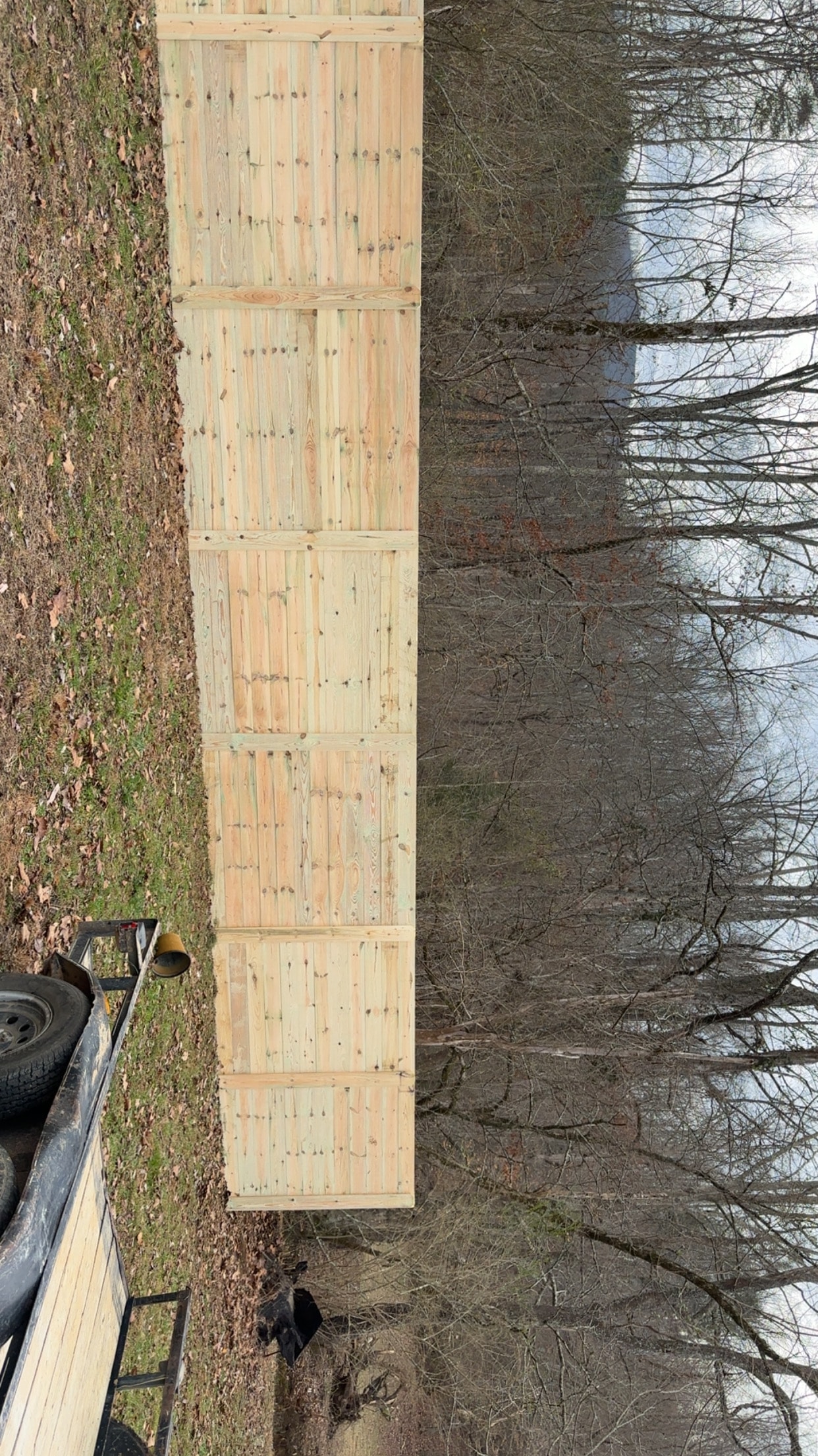 Horizontal privacy fence run with trailer wooded property