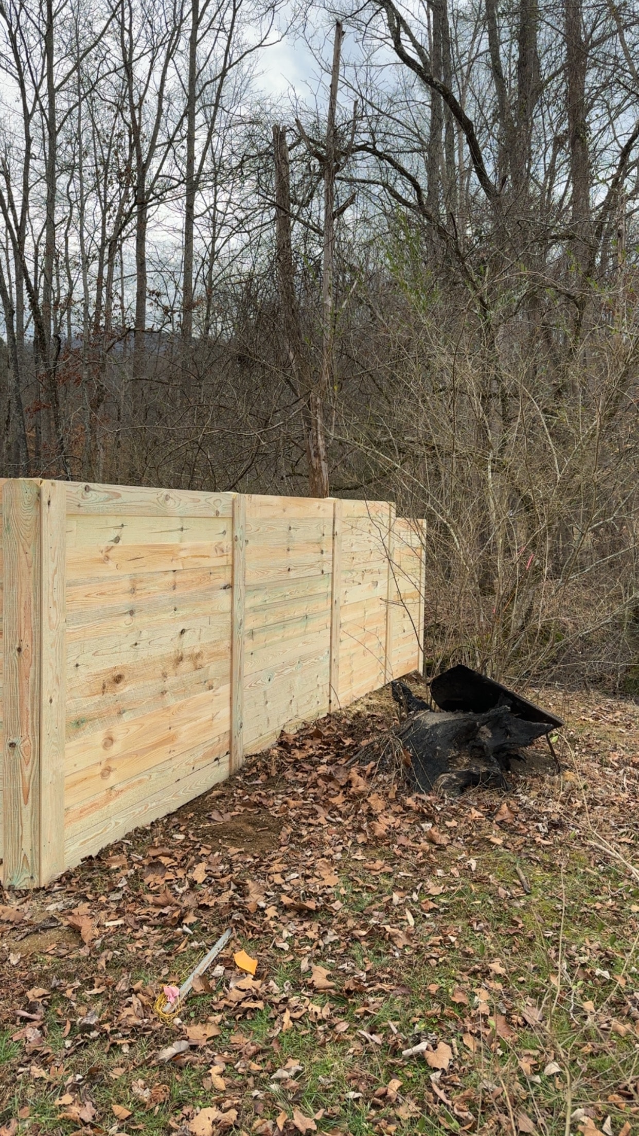 Horizontal privacy fence sections wooded backyard