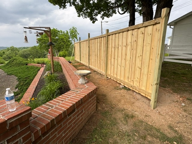 6 foot wood privacy fence beside brick garden wall — East Tennessee residential
