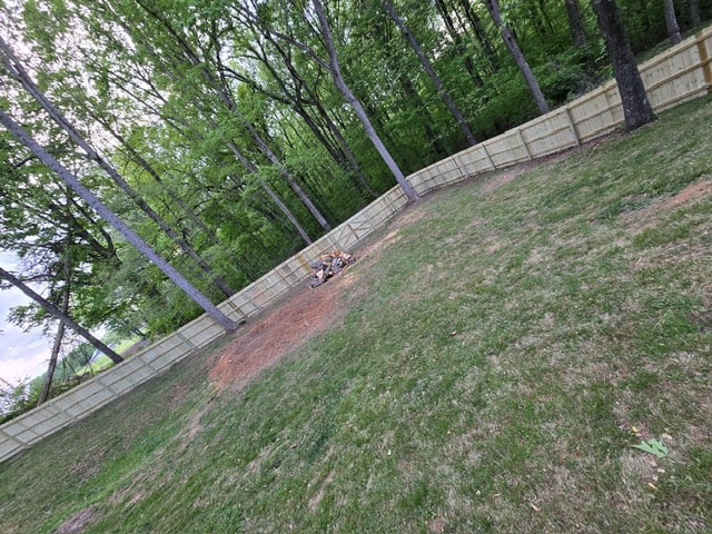6 foot wood privacy fence on sloped lot along tree line — East Tennessee