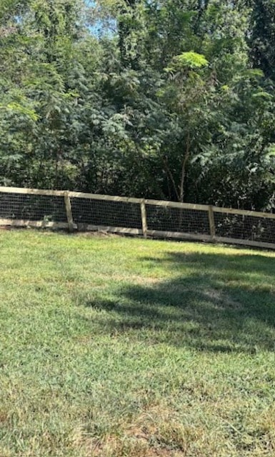 Wood post and hog wire backyard fence along tree line — East Tennessee residential