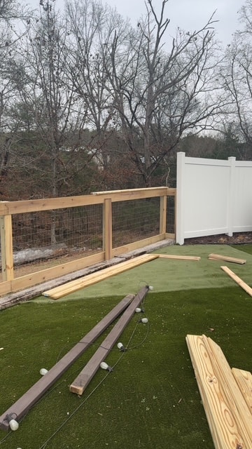 Hog wire fence installation in progress with vinyl privacy panel — Knoxville, TN